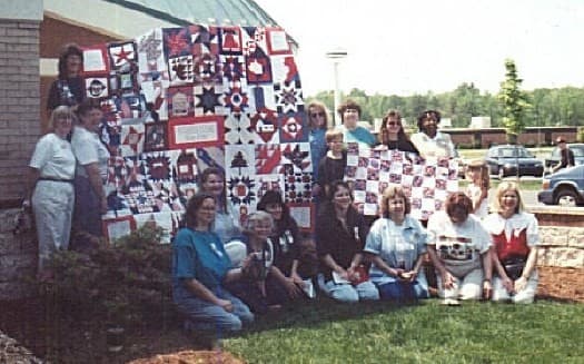Nifty Fifty Quilting Gathering holding the Breast Cancer Charity Quilt